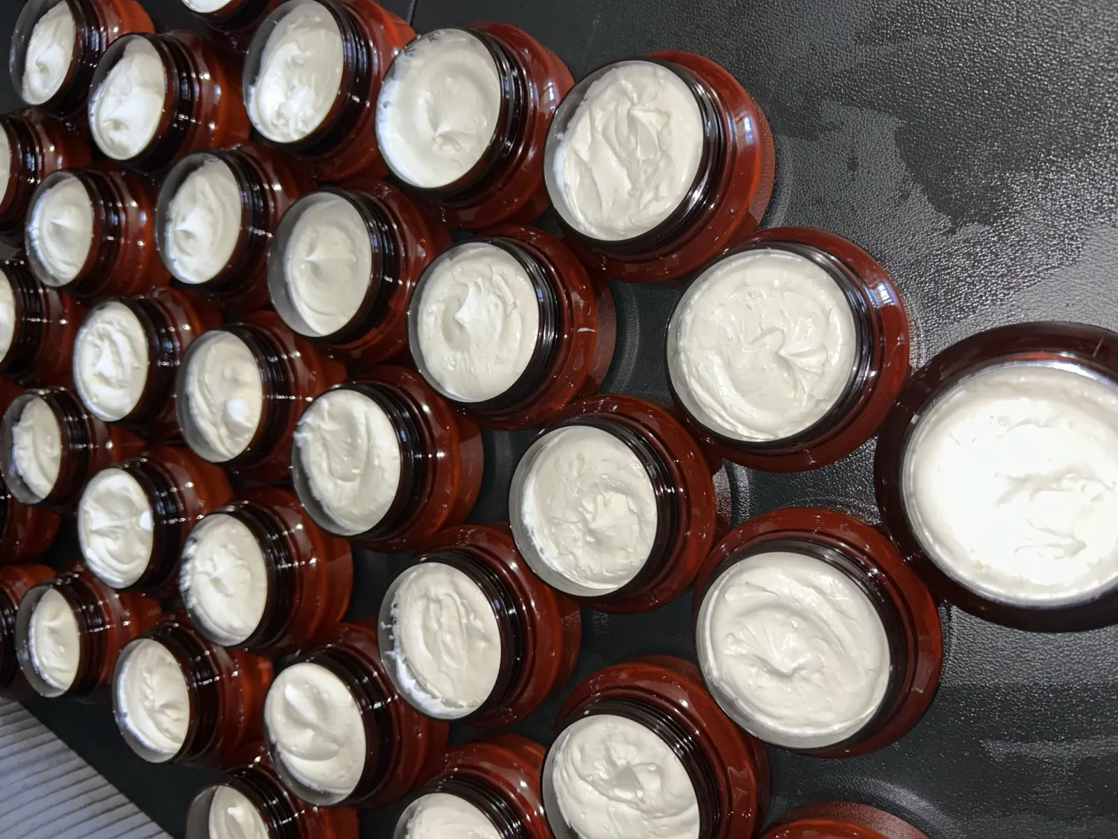 Rows of freshly filled amber jars of whipped shea butter